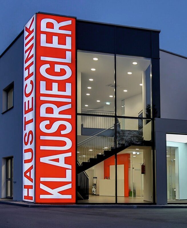 Beleuchteter Werbeturm bei Nacht